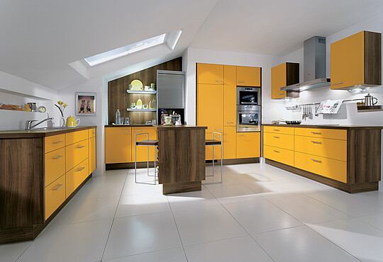 Gelbe Küche mit Halbinsel in einer Dachwohnung