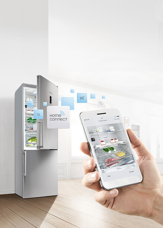 Smartphone mit dem Inhalt des Kühlschranks vor einem halb geöffnetem Kühlschrank
