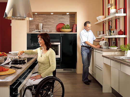 Rollstuhlfahrerin in einer Küche 